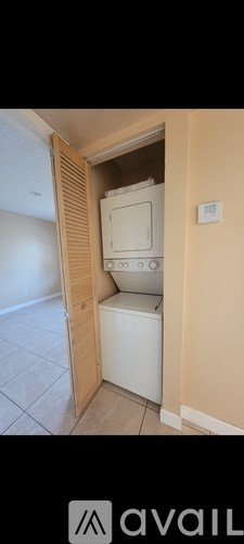 A white washing machine is tucked into a small space in a home.
