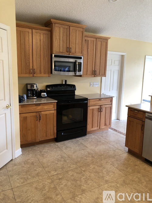 A kitchen with wooden cabinets and black appliances.