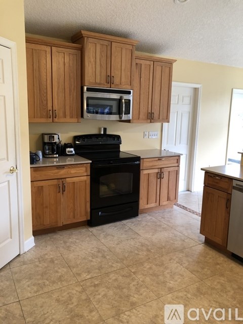 A kitchen with wooden cabinets and black appliances.