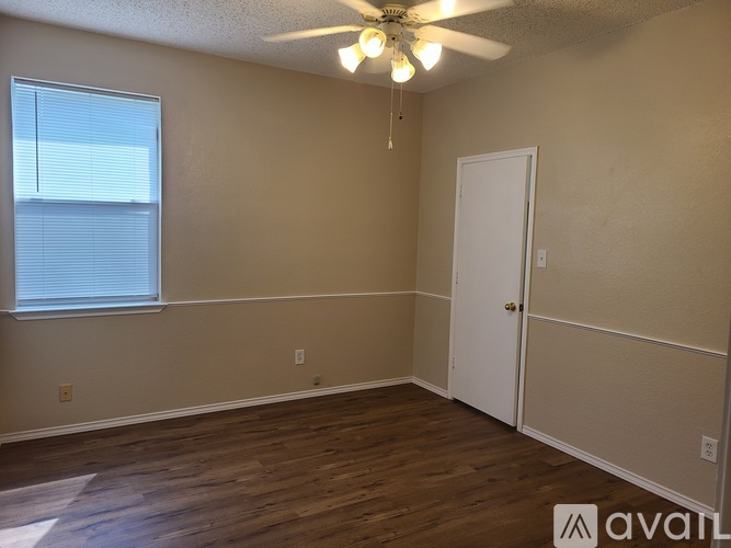 A room with a ceiling fan and a door.