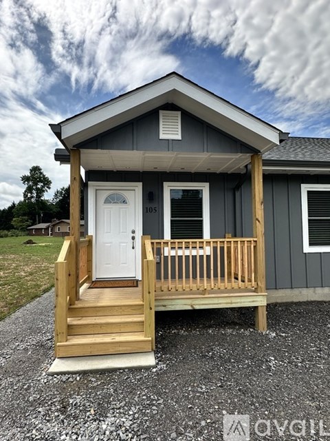 A small house with a porch and a white door.