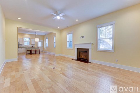 A spacious living room with a fireplace and hardwood floors.