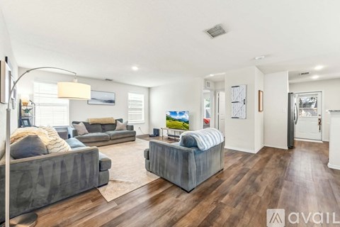 A living room with a grey sofa and a grey armchair.