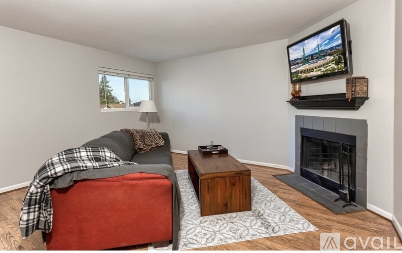 A living room with a red chair and a fireplace.