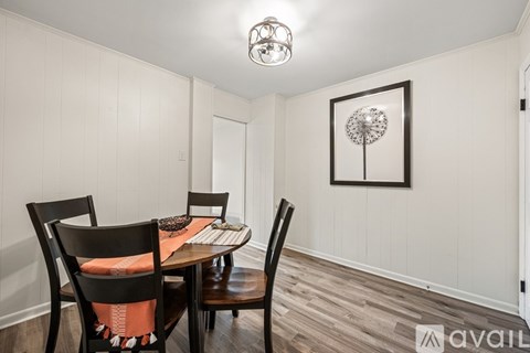 A dining room with a wooden table and chairs.