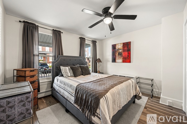 A bedroom with a large bed and a ceiling fan.