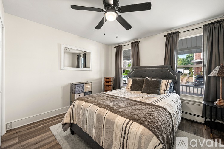 A bedroom with a large bed and a ceiling fan.