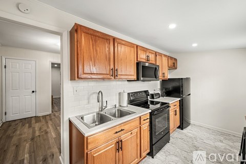 A kitchen with wooden cabinets and black appliances.