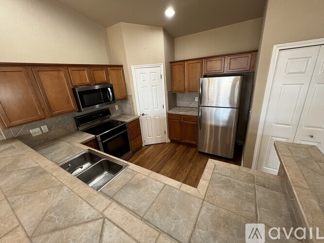 A kitchen with wooden cabinets and a stainless steel refrigerator.