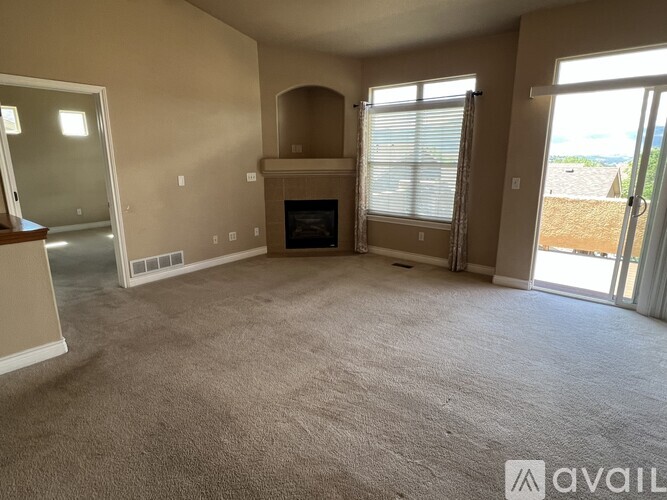 A living room with a fireplace and sliding glass doors.