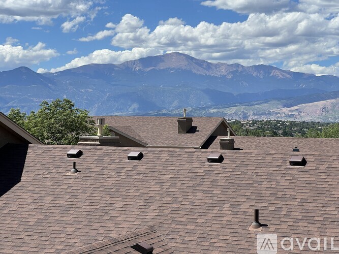 A house with a brown roof and a mountain in the background.