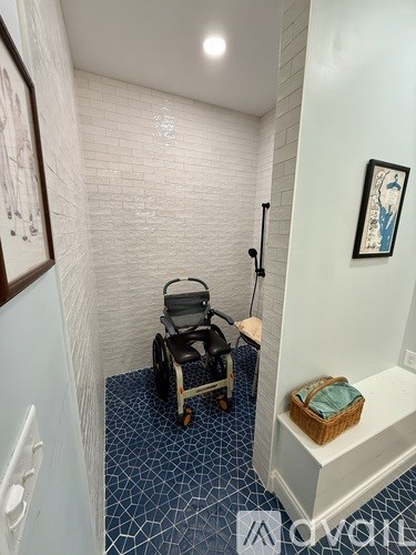 A white hallway with a stroller and a basket on a bench.