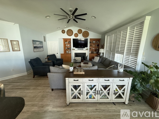 A living room with a grey couch and a white cabinet.