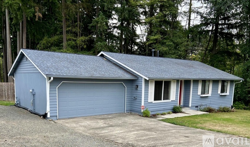 A blue house with a garage door and a driveway.