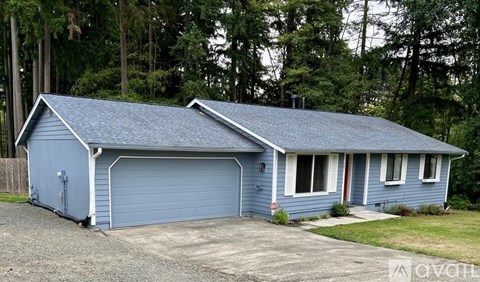 A blue house with a garage door and a driveway.