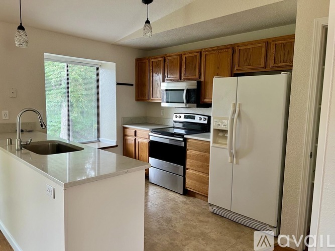 A kitchen with white appliances and wooden cabinets.