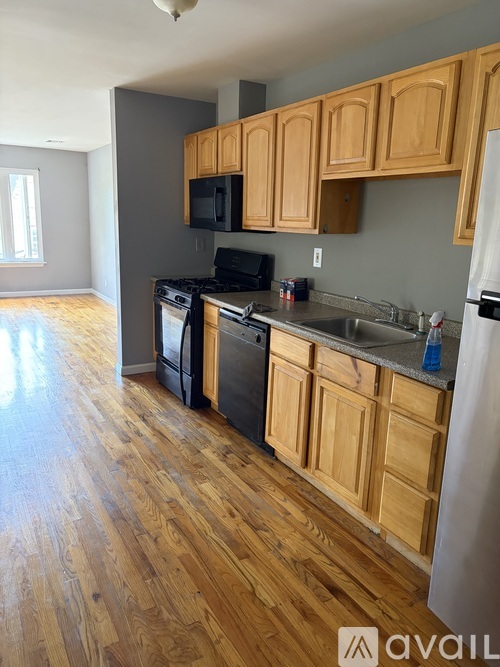 A kitchen with wooden cabinets and a black stove top oven.