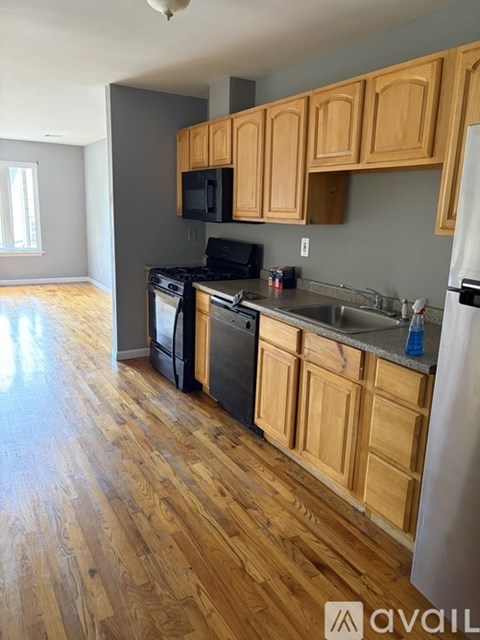 A kitchen with wooden cabinets and a black stove top oven.