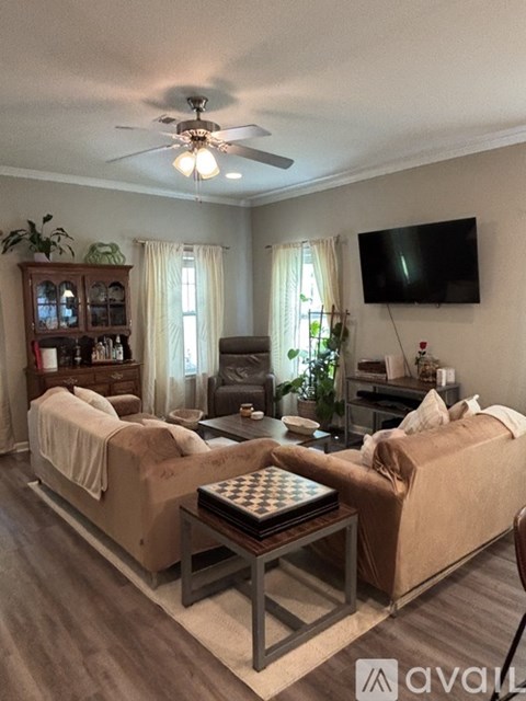 A living room with two couches and a television mounted on the wall.