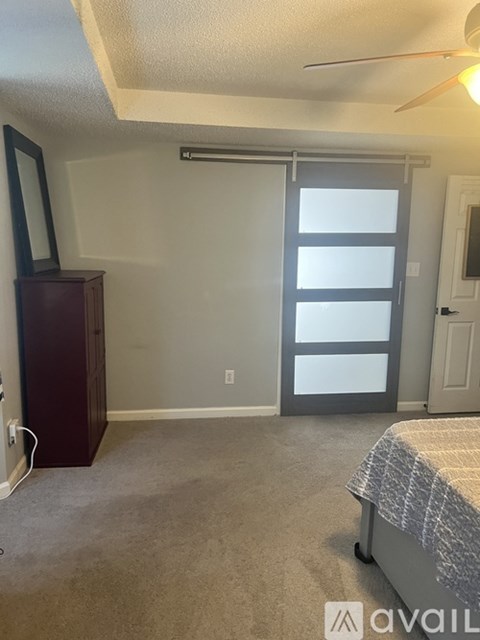 A bedroom with a bed, dresser, and mirror.