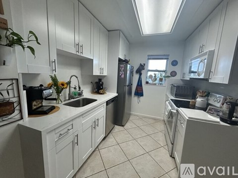 A kitchen with white cabinets and a large island.