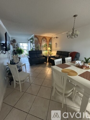 A living room with a white dining table and chairs.