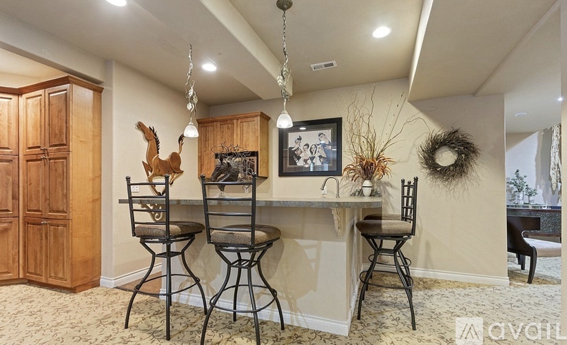 A kitchen with a wooden cabinet and a black chair.