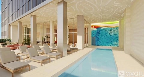 A pool area with chairs and a waterfall.