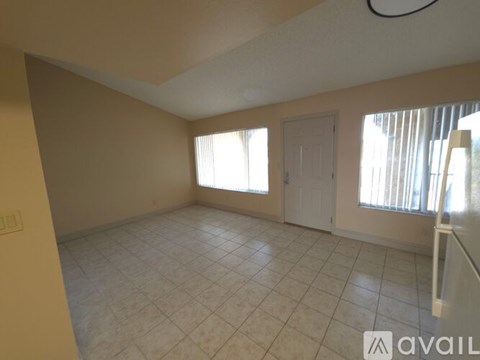 A room with tiled flooring and a window with blinds.