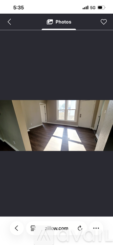 A photo of a room with a window and wooden flooring.
