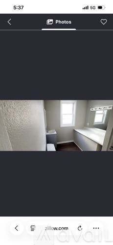 A room with a window and a bathtub.