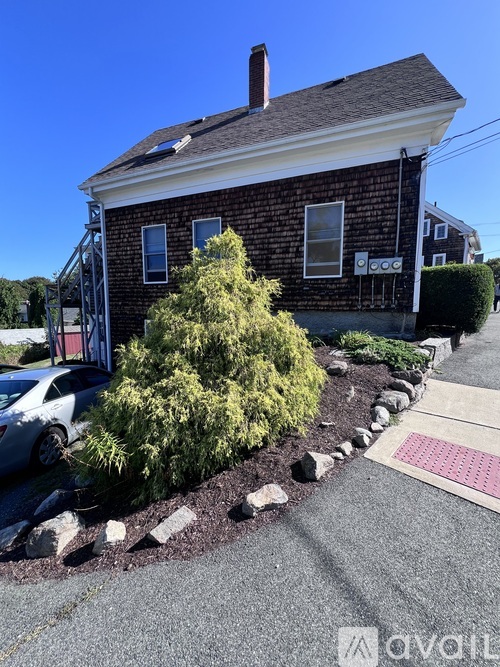 A house with a red brick exterior and a white car parked in front.