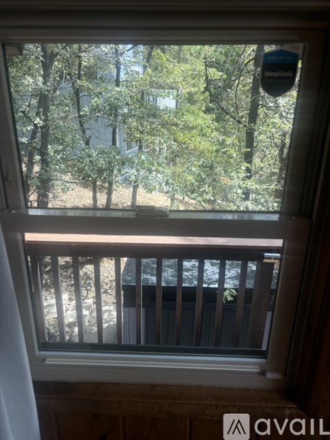 A view from a window looking out to a deck and trees.