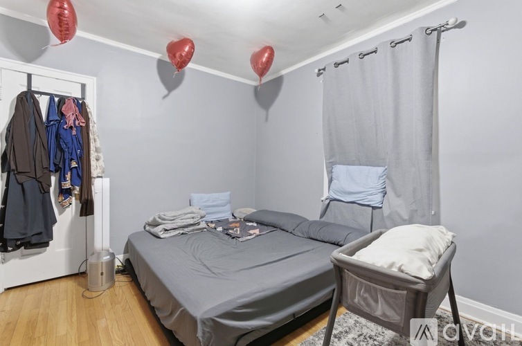 A bedroom with a bed, a chair, and a closet with clothes.