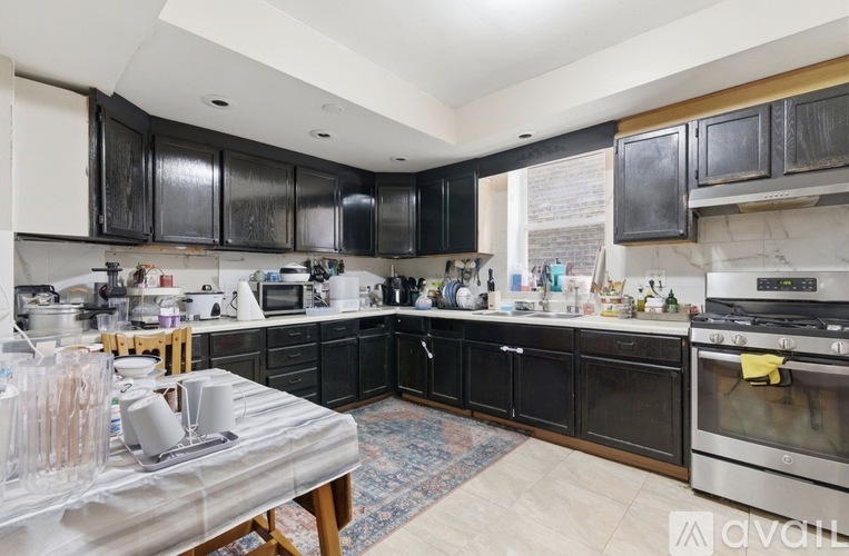 A kitchen with black cabinets and a stainless steel oven.