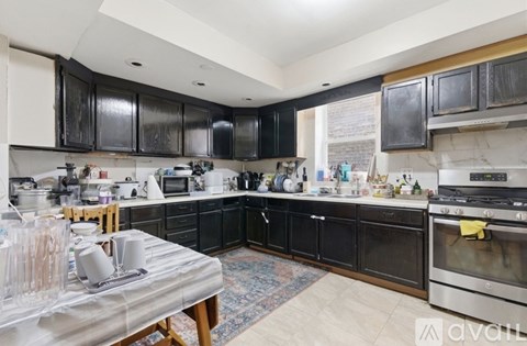 A kitchen with black cabinets and a stainless steel oven.