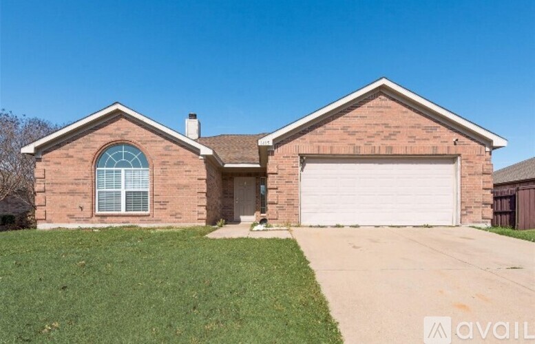 A brick house with a garage door and a window.