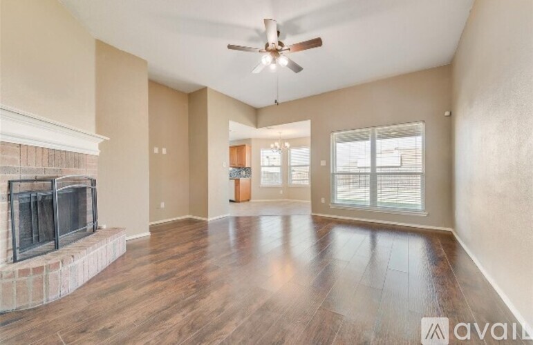 A spacious living room with a fireplace and hardwood floors.