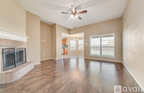 A spacious living room with a fireplace and hardwood floors.