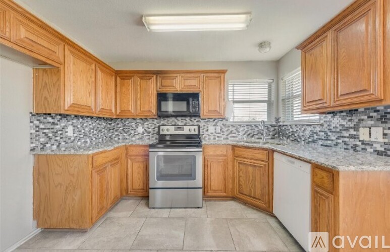 A kitchen with wooden cabinets and a granite countertop.
