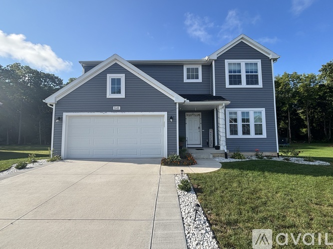 A two-story house with a garage and a driveway.