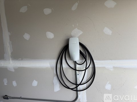 A white plug is plugged into a black cord.