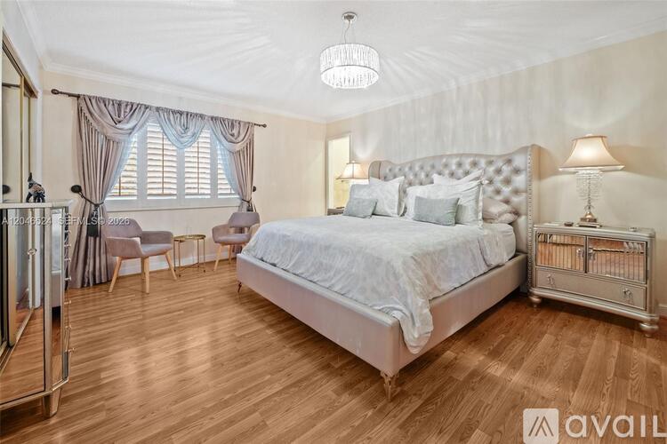 A bedroom with a large bed and a chandelier.