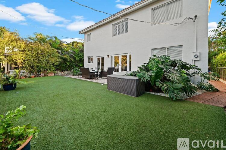 A house with a white exterior and a green lawn in front.