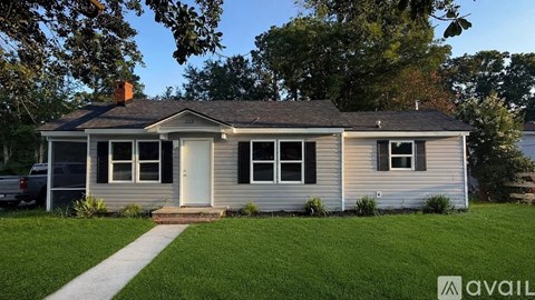 A house with a white door and windows is for sale.