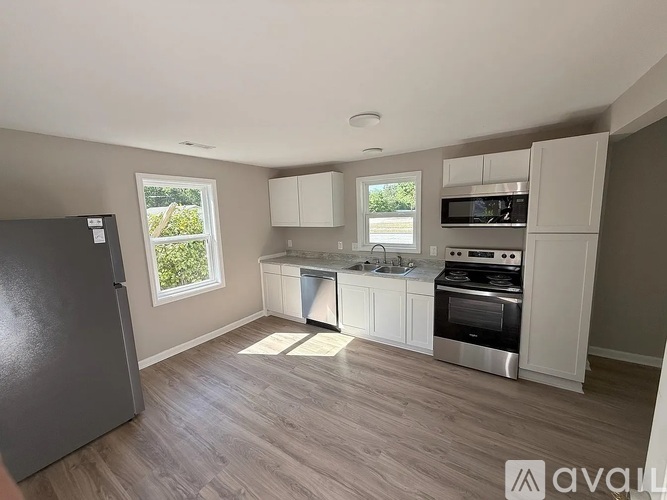 A kitchen with a refrigerator, oven, and microwave.