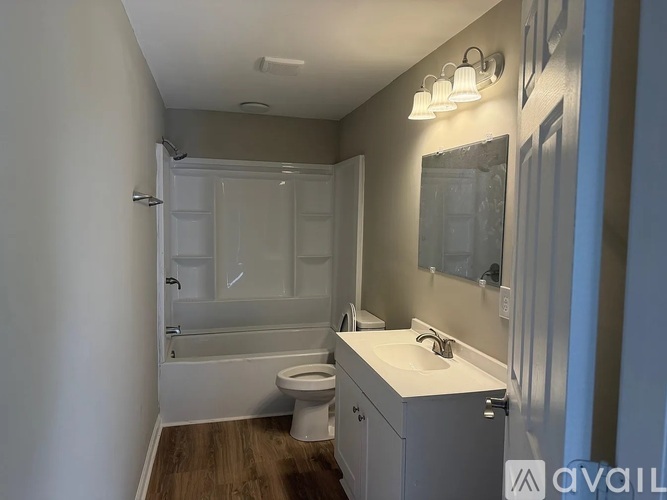 A bathroom with a toilet, sink, and bathtub.