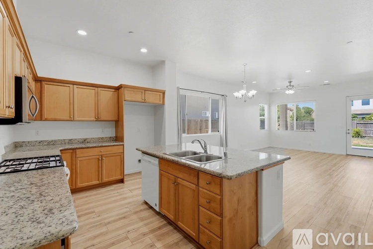 A kitchen with wooden cabinets and a granite countertop.