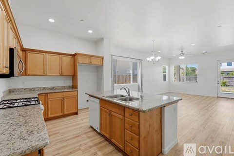 A kitchen with wooden cabinets and a granite countertop.
