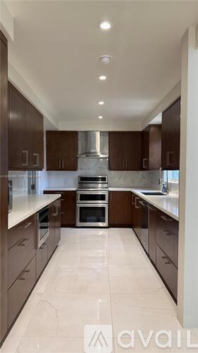 A modern kitchen with brown cabinets and a central island.